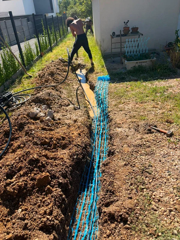 Pose d'une canalisation d'eau en tranchée dans le jardin